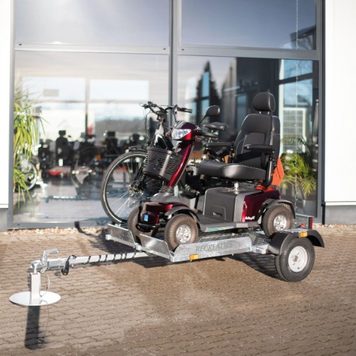 Scootwagen met een rode scootmobiel en een fiets erop